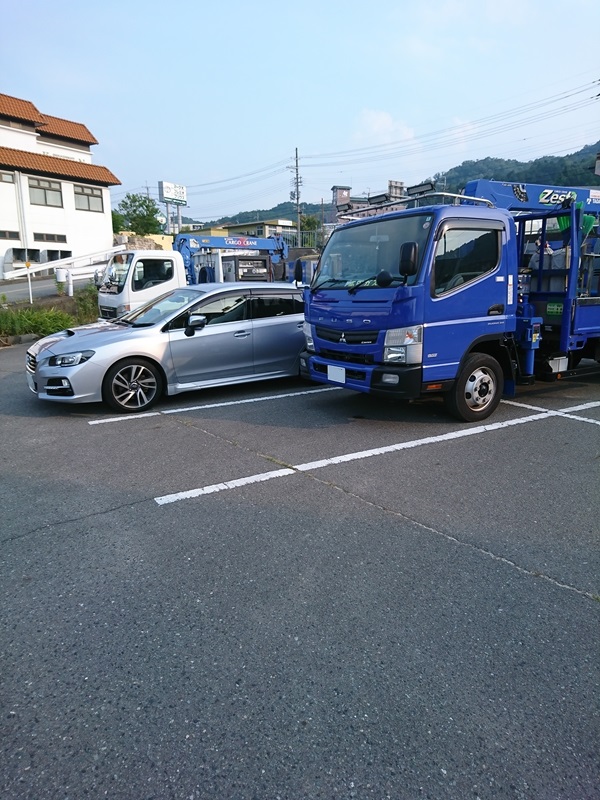 出先でトラックに挟まれて駐車したレヴォーグ